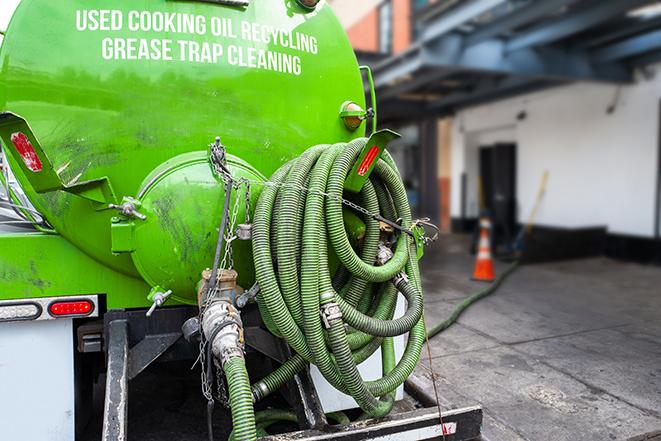 a technician pumping a grease trap in a commercial building in Commerce City, CO